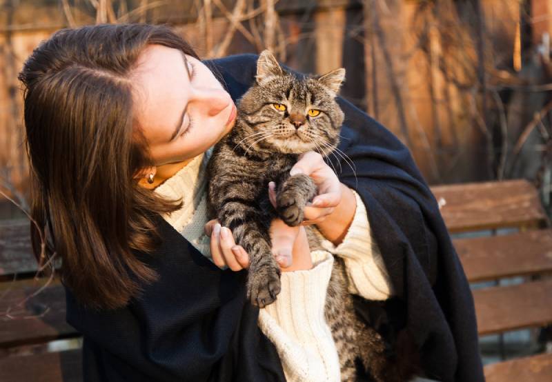 young woman with her pet cat outdoors