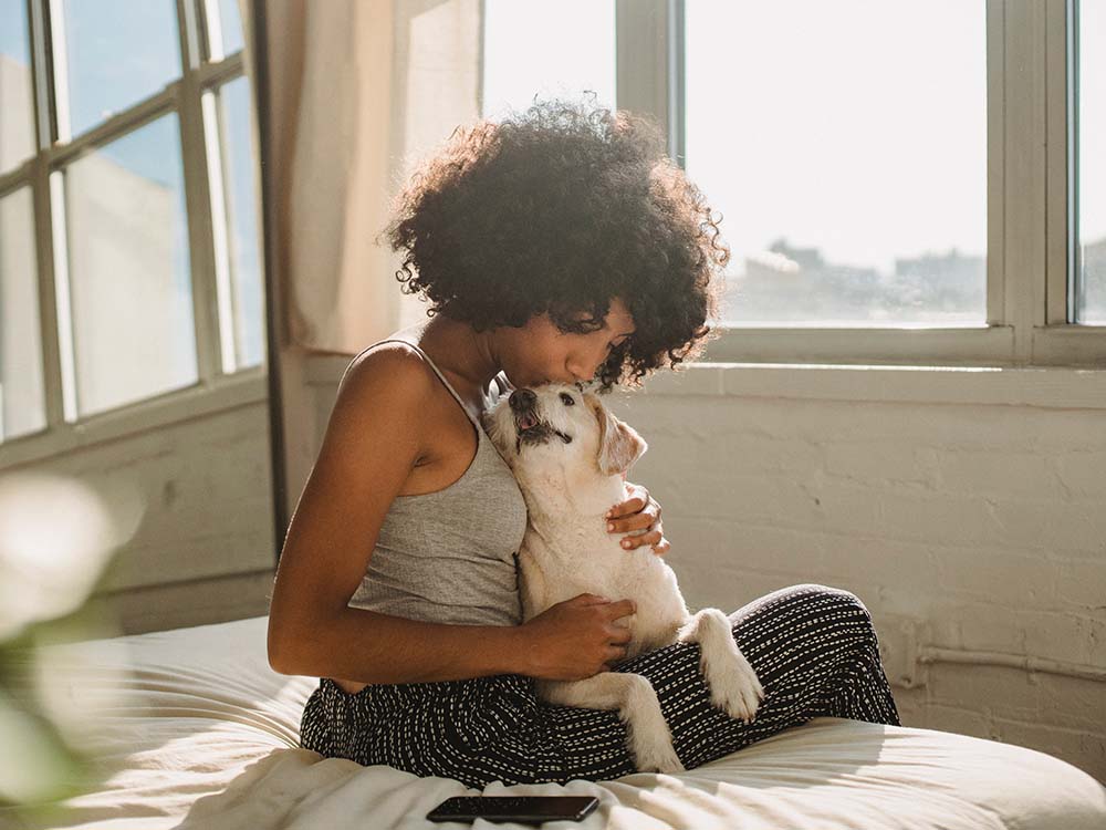 woman comforts dog with separation anxiety