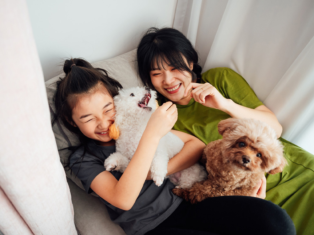 woman and child with two pet poodles