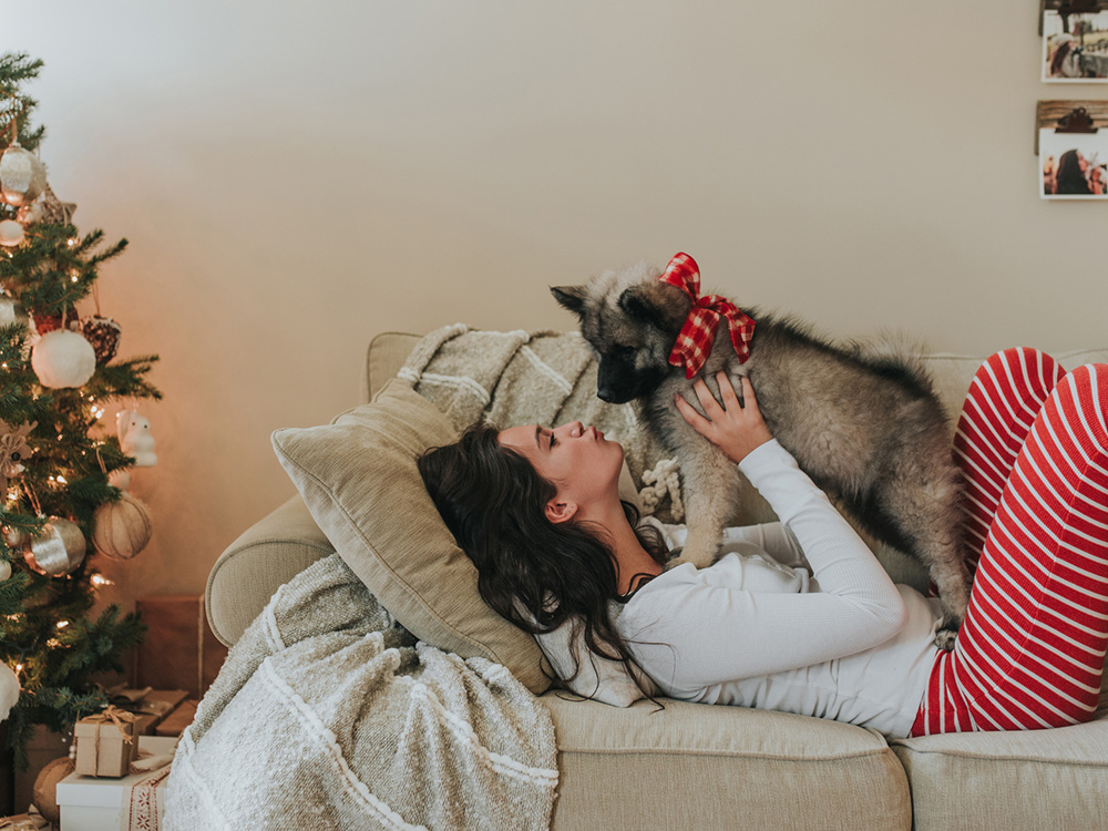 Woman holding newly gifted puppy with bow