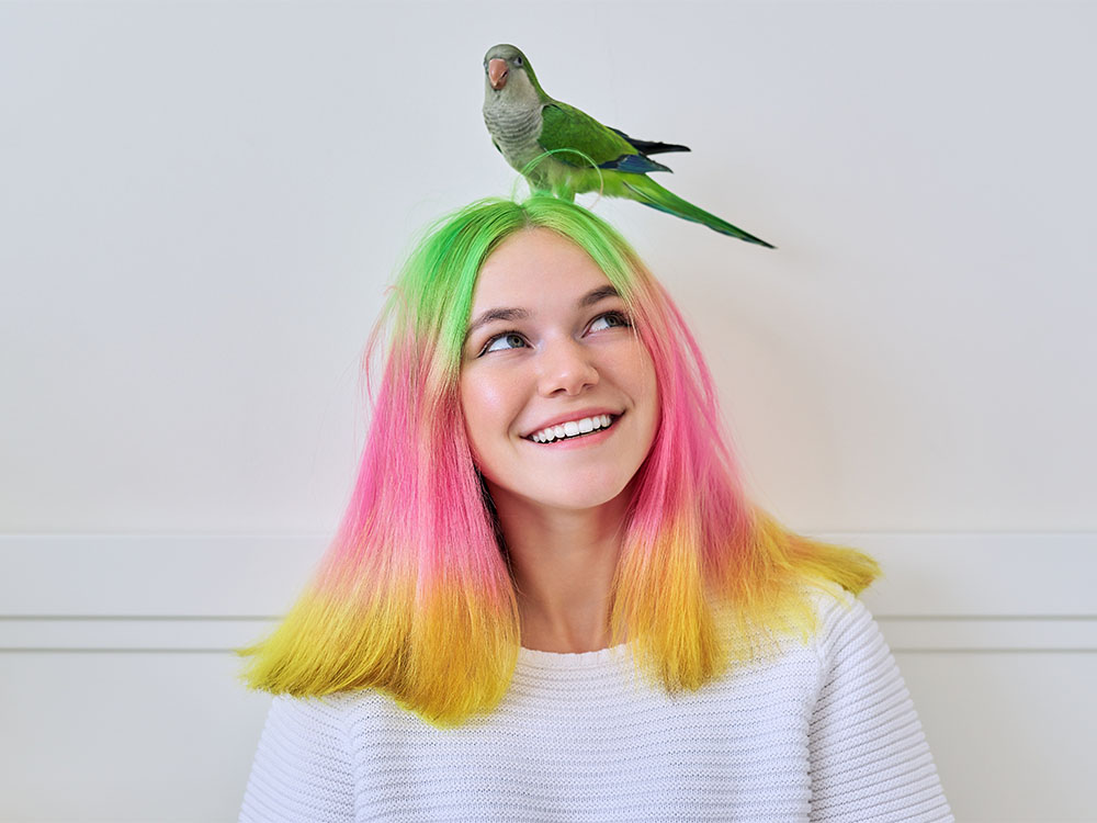 Girl with pet bird on head