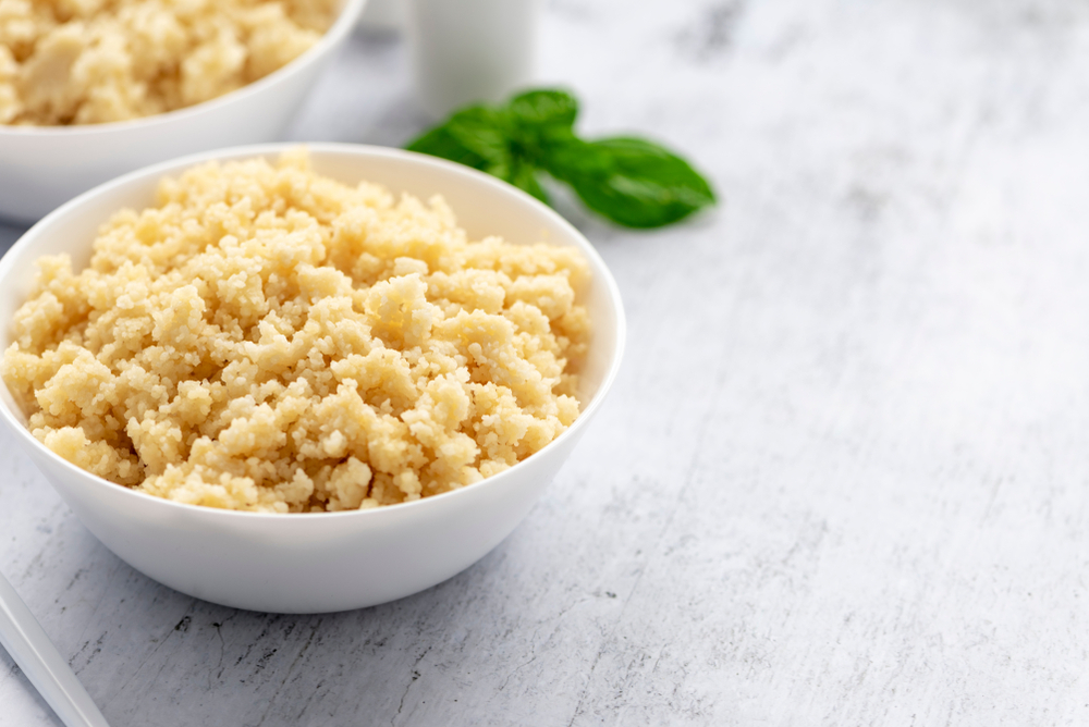 Cooked couscous in a white ceramic bowl on the table