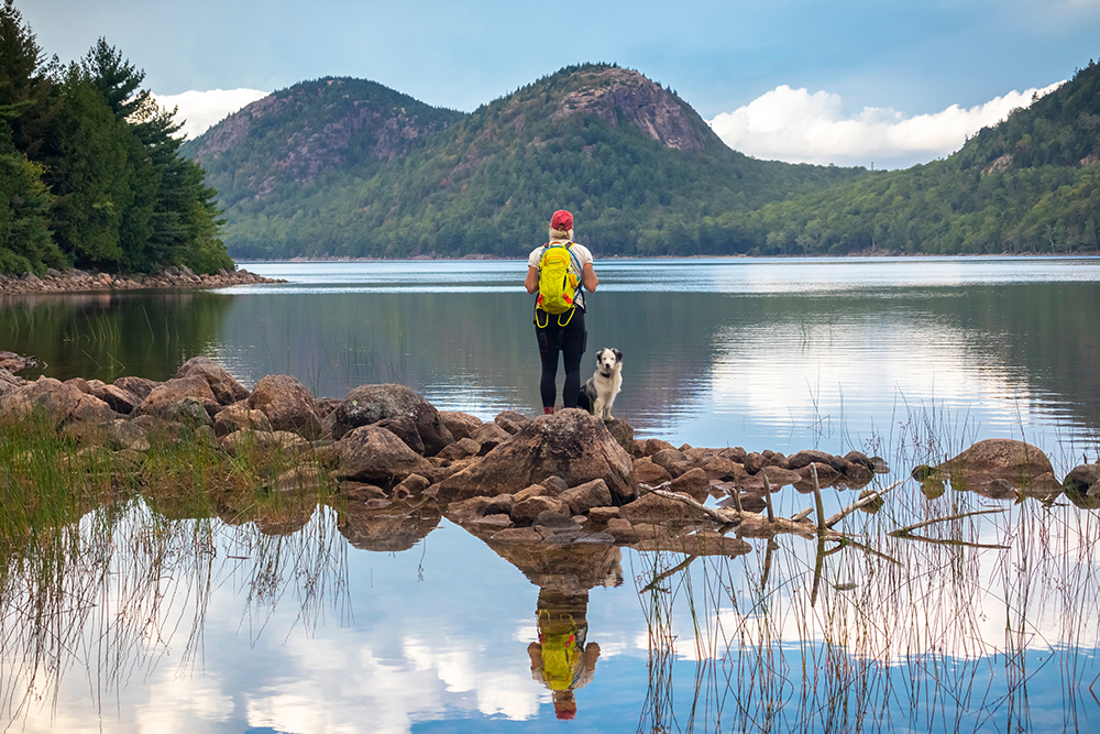 Female hiker and her dog at Jordan Pond